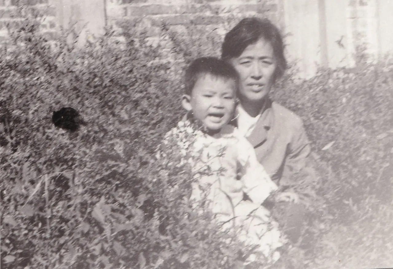 第1幅：花丛旁女子抱幼童。